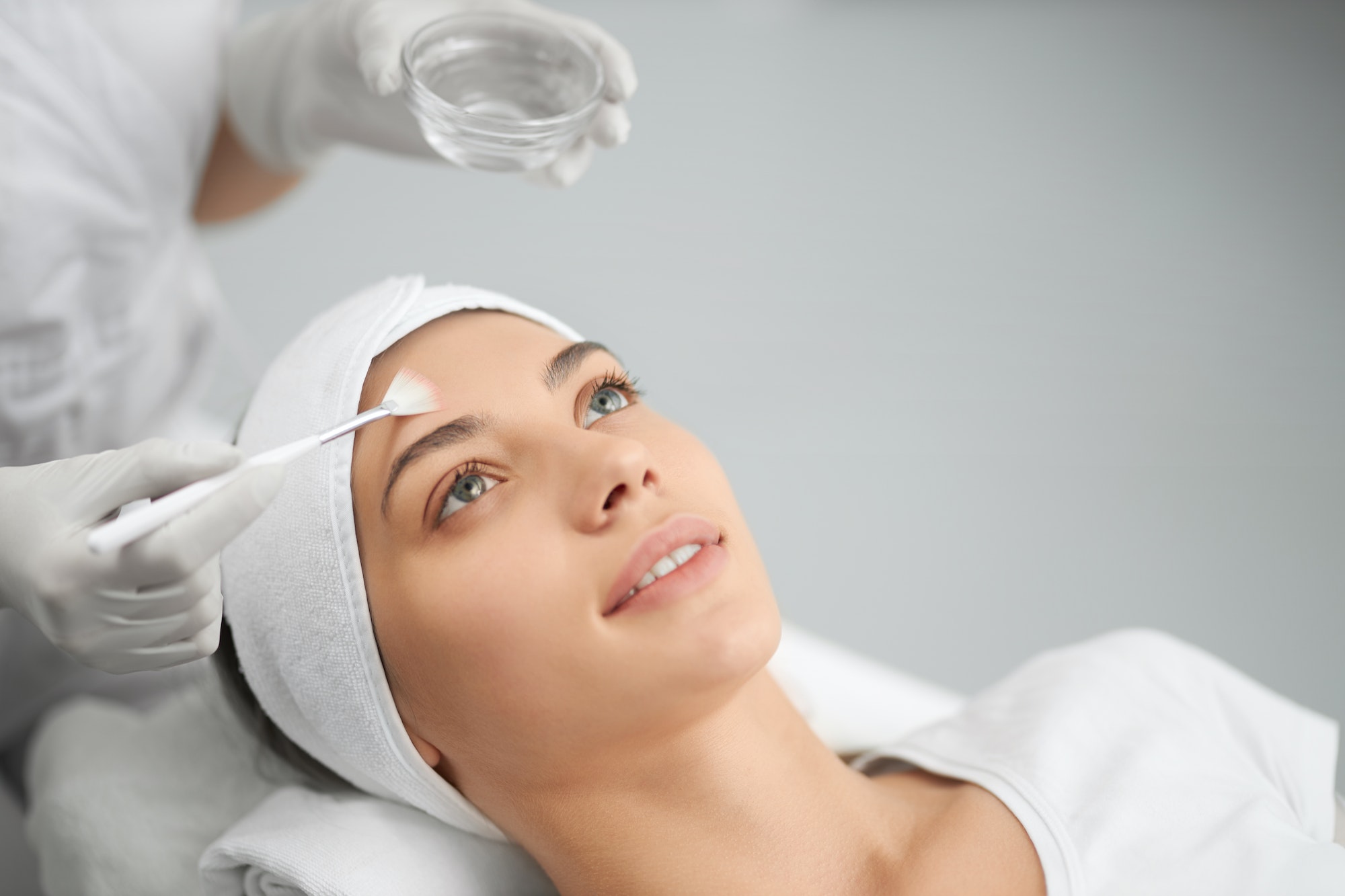 Woman on procedure for face in beautician